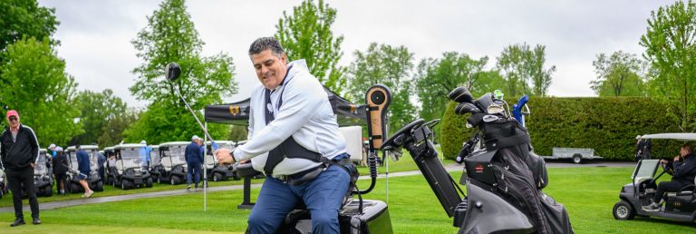 Joueur de golf sur un fauteuil roulant motorisé, prêt à jouer au Super Bowl Bash 2025.