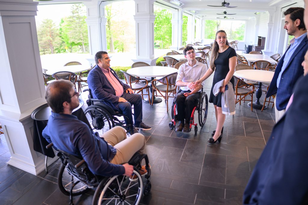 Groupe d'amis diversifiés discutant dans un restaurant avec vue sur le golf